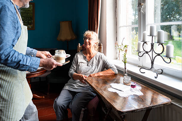 istock senior woman is served coffee and cake 2234622448