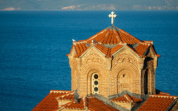 A close-up of the St. John the Theologian Orthodox Church in Kaneo. Sunrise over the church, accompanied by birdsong and a lake view.