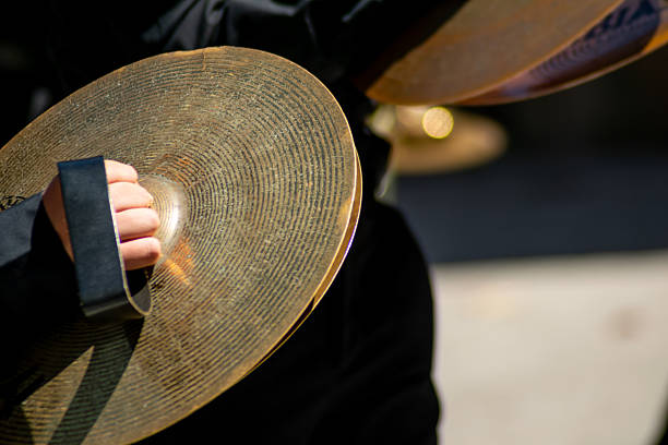 Musician playing a pair of brass cymbals during a musical performance