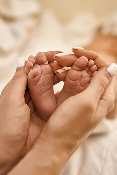 istock Newborn Baby Feet in Parent's Hands 2234630013