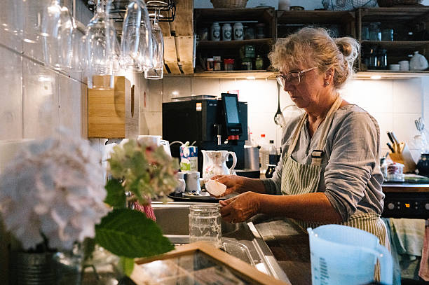 istock senior woman doing the dishwasher in a retro styled kitchen 2234632554