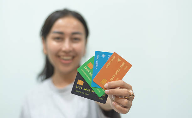 istock Asian Woman Displaying Multiple Colored Credit Cards on White Background – Studio Shot 2234632586