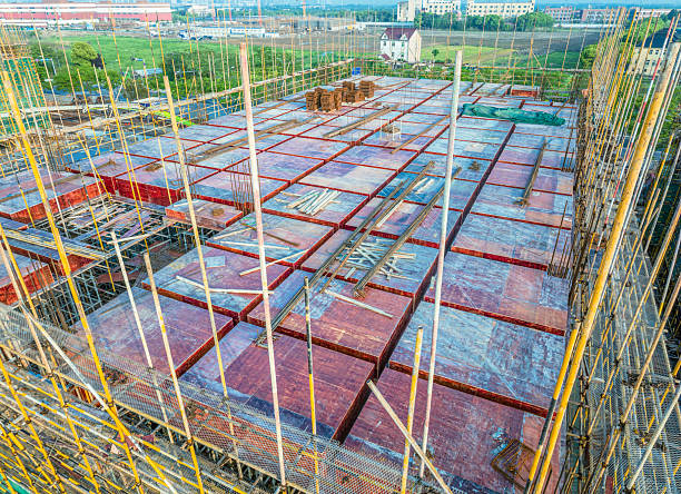 istock Construction site foundation with extensive wooden formwork and steel rebar grid prepared for pouring concrete slab. 2234633886