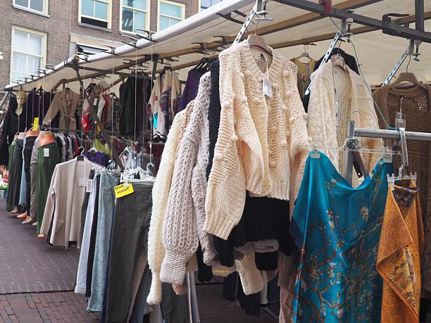 Leiden, Netherlands – September 02, 2023: Market stall displaying wool sweaters, jackets, trousers, and scarves in Leiden street market.
