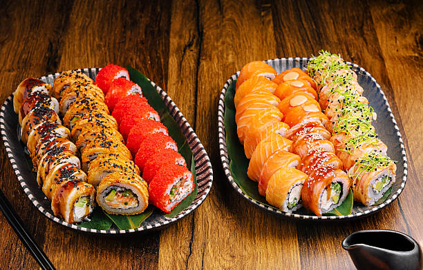 istock Sushi platters featuring diverse rolls and sashimi on a wooden table 2234636575