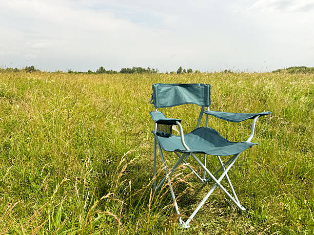 istock Folding chair in a green field 2234637570