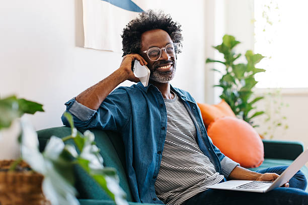 istock Mature man enjoying remote work from home, talking on a smartphone on a couch 2234642077