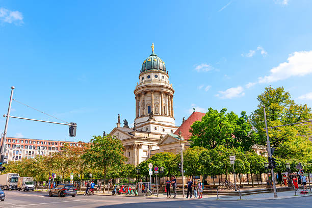 Berlin, Germany - August 16, 2025: Scenic view of a historic dome-shaped building surrounded by lush trees on a sunny day in Berlin.