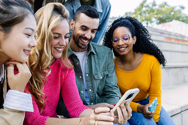 istock Happy multiracial millennial friends having fun outdoors using mobile phones 2234646272