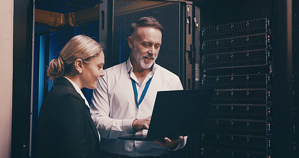 istock Laptop, discussion and team of engineers in server room for technical support, database or cybersecurity. Computer, collaboration and people with system upgrade in data center for network programming 2234648685