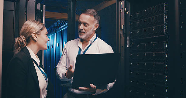 istock Laptop, collaboration and team of engineers in server room for technical support, database or cybersecurity. Computer, discussion and people with system upgrade in data center for network programming 2234648707