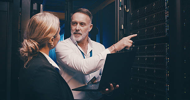 istock Laptop, pointing and team of engineers in server room for technical support, database or cybersecurity. Computer, teamwork and people with system upgrade in data center for network programming. 2234648720