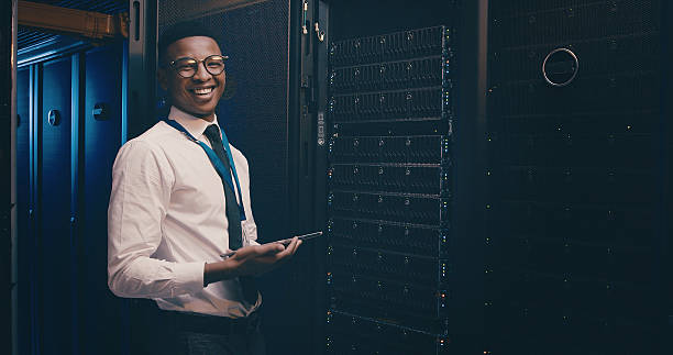 istock Portrait, engineer and man with tablet, server room or happy for network engineering or programming. Data center, IT specialist and black person with smile for information technology and maintenance 2234648750