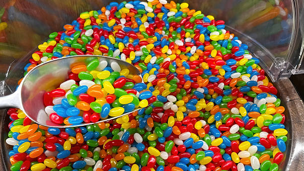 Colorful jelly beans scooped up with a large shovel in the candy aisle.