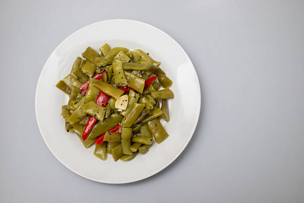 boiled green beans with garlic on white plate