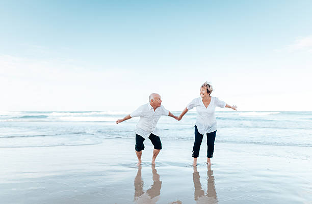 istock senior couple jumping at the beach 2234656234