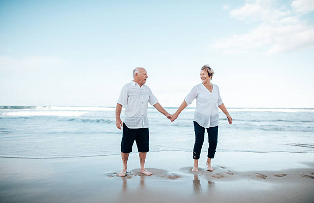 istock senior couple jumping at the beach 2234656263
