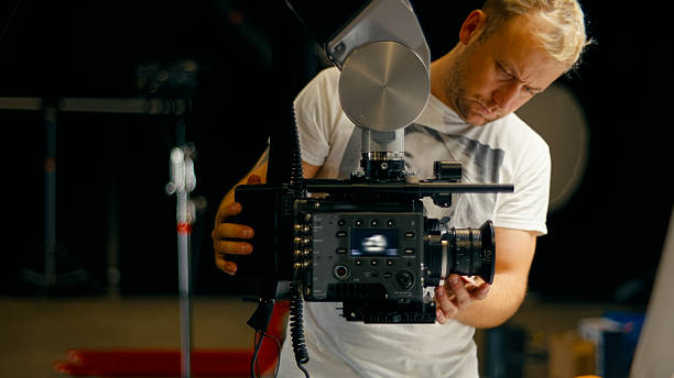 Interior of a professional photography and film studio with high quality camera equipment ready to shoot photos and video. Camera operator adjusting the equipment