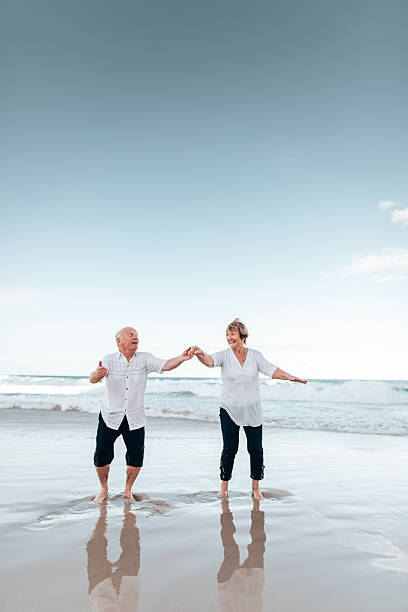 istock senior couple jumping at the beach 2234656461