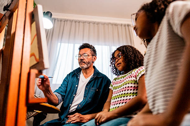 istock Father teaching his daughters how to paint at home 2234656628