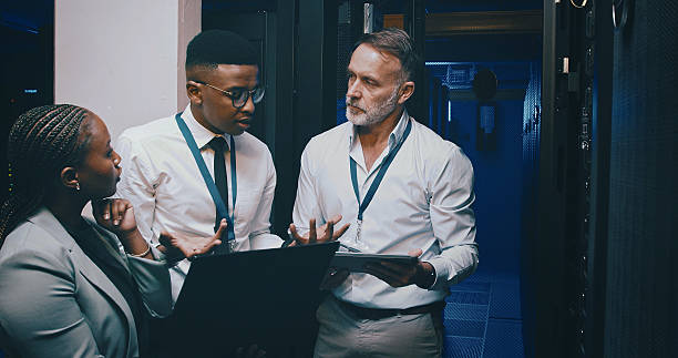 istock Talking, network and people with laptop in server room for cybersecurity, diagnostics and IT support. Team, meeting and workers on tech, tablet and hardware for system update, database and backup 2234657283