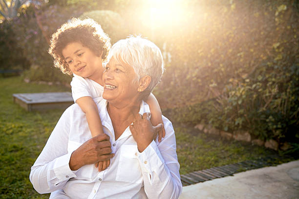 istock Grandma Hugged by Grandson in Glowing Garden Backlight 2234659936