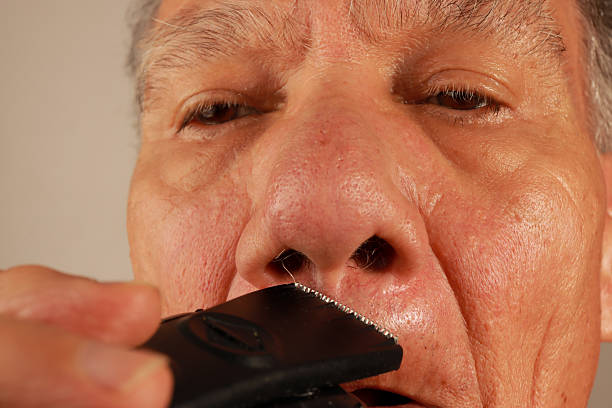 Man trimming his nose hairs with an electric razor
