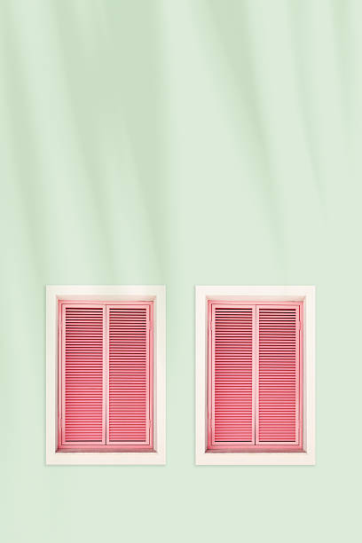 istock Pastel pink facade with pink shuttered windows, summer sunlight palm leaf shadow, tropical vacation view. Travel blogs, resort branding, coastal lifestyle visual. Minimal aesthetic trend, copyspace 2234660402