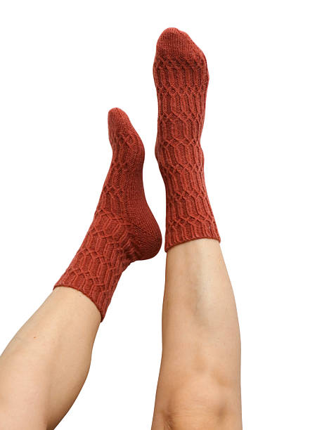 istock Female legs in terracotta hand knitted wool socks 2234662170