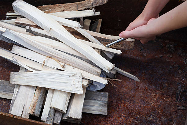 istock Hands are arranging kindling and firewood, preparing to light a fire for a cozy evening. This simple scene evokes a feeling of warmth, comfort, and the anticipation of relaxing outdoors. 2234668696