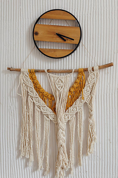 istock Stylish macrame and weaving wall decor hanging underneath a wooden clock 2234669629