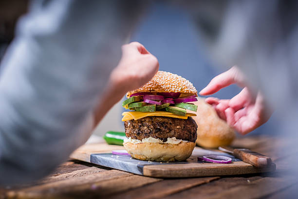 istock Freshly Assembled Gourmet Burger With Hands Plating Before Serving 2234670031