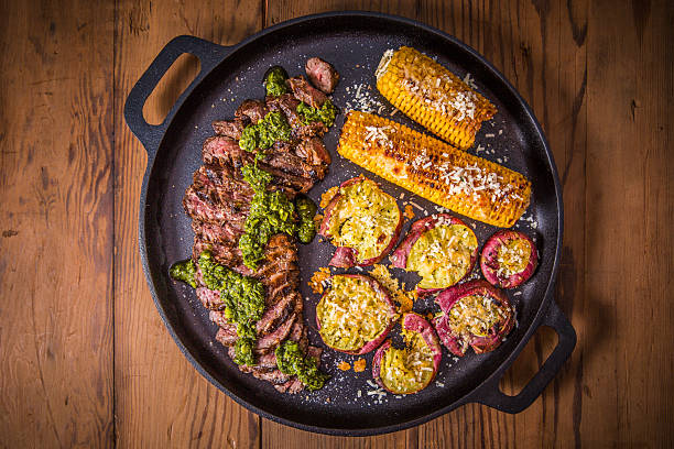 istock Grilled Steak and Vegetables Served in a Cast Iron Pan on Wooden Table 2234670838
