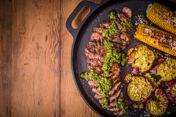 istock Grilled Steak Served with Corn, Sweet Potatoes, and Chimichurri Garnish 2234670854