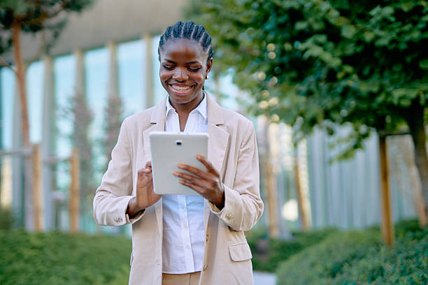istock Smiling businesswoman using digital tablet outdoors 2234672544