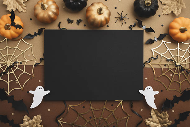istock Halloween party composition with empty black card and festive decoration from pumpkins, bats, spider web, ghosts on golden background top view. 2234672766