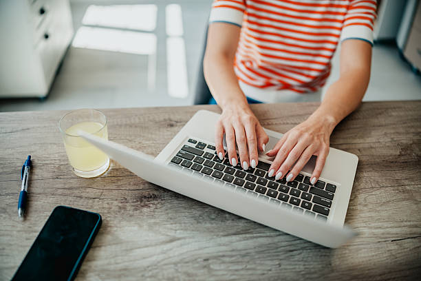 istock Engaged young adult working on a laptop at a cozy kitchen table during a productive afternoon 2234675033