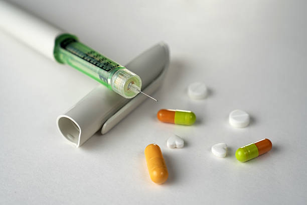 istock Insulin pen and scattered medication on a white background 2234679384
