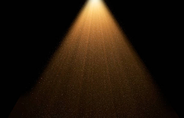 istock Golden spotlight is illuminating dust particles floating in dark room 2234681135