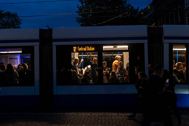 Amsterdam, Netherlands - August 22, 2025: Tram 12 makes its stop at Prinsengracht at dusk.