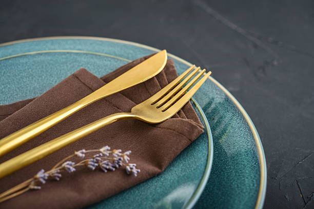 istock table place setting with blue plates and golden cutlery on black  background 2234684359