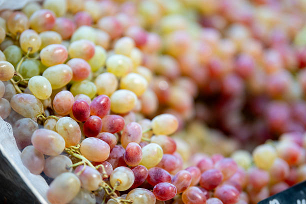 Ripe green grapes on a store counter, a fresh and abundant background for healthy food concepts, grocery themes, and product display.