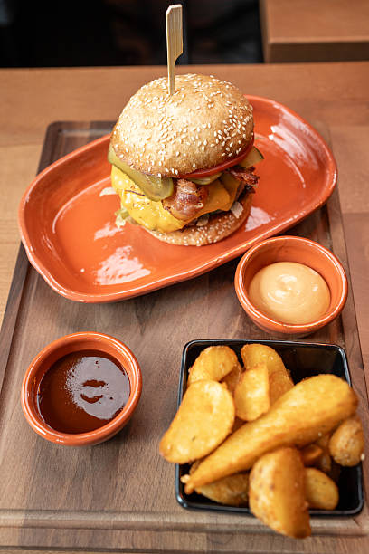 Mouthwatering burger platter with crispy potatoes and dipping sauces