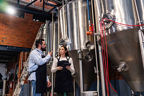 istock Coworkers talking and using digital tablet at brewery 2234690889