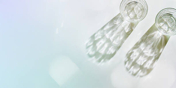 istock Water Glasses with Shadows and sunlight Reflection on white, banner, colored toned photo minimal style, aesthetic top view summer still life, refraction throug crystal shine cups, caustics 2234691850