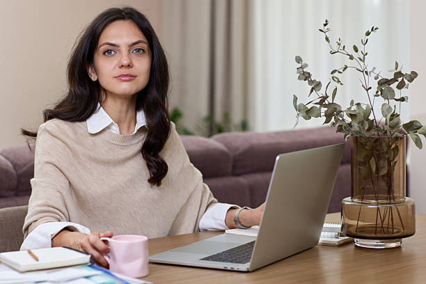 istock woman looking at camera at home. Successful lady working at home. 2234694889