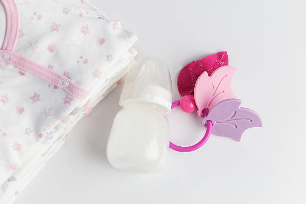 istock Baby bottle with pacifier and folded clothes flat lay 2234695709