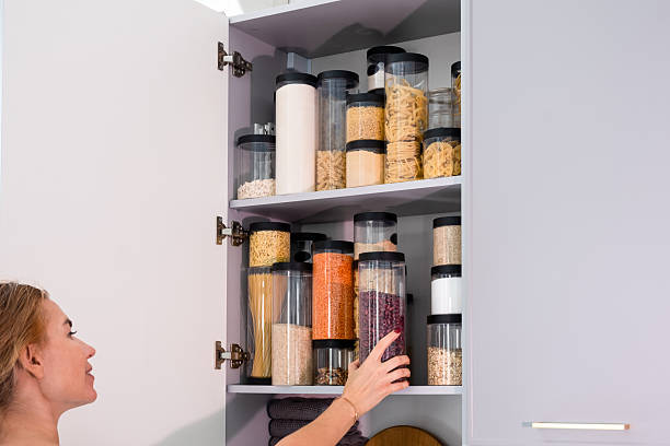 istock Organized kitchen pantry with cylindrical plastic jar for storing loose products,  in grey tones 2234697063