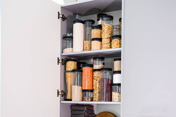 istock Organized kitchen pantry with cylindrical plastic jar for storing loose products,  in grey tones 2234697112