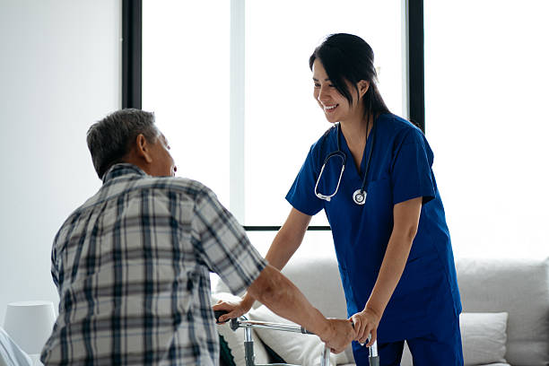 istock Senior Patient Assisted by Home Caregiver with Mobility Walker 2234702575